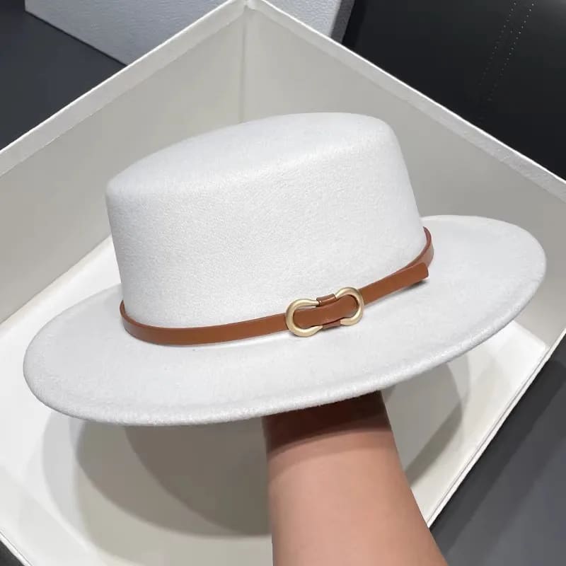 A white hat with brown leather band in a box.