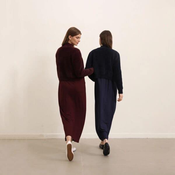 Two women are walking together holding hands.