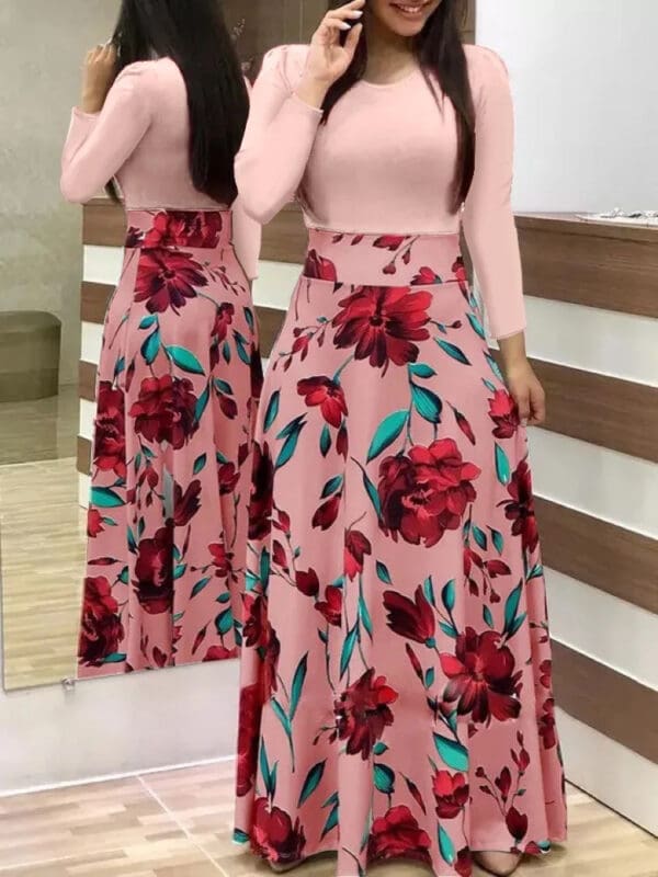 A woman in pink and red floral print dress standing next to mirror.