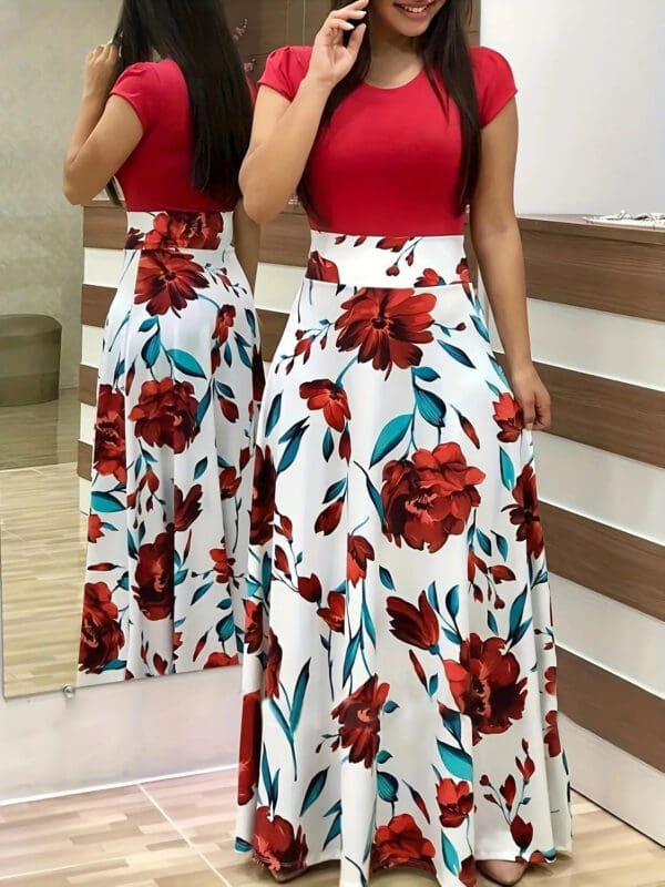 A woman standing in front of a mirror wearing a red top and floral skirt.