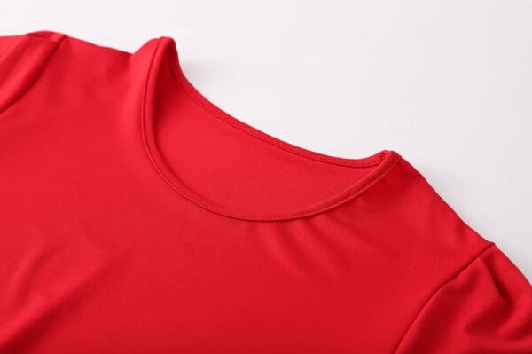 A close up of the neck and shoulders of a red shirt.