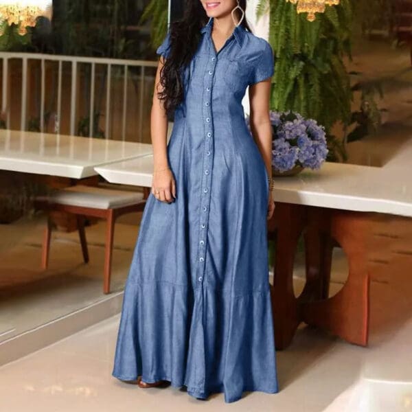 A woman standing in front of a table wearing a blue dress.