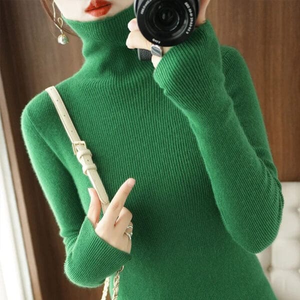 A woman taking a selfie in a green sweater.