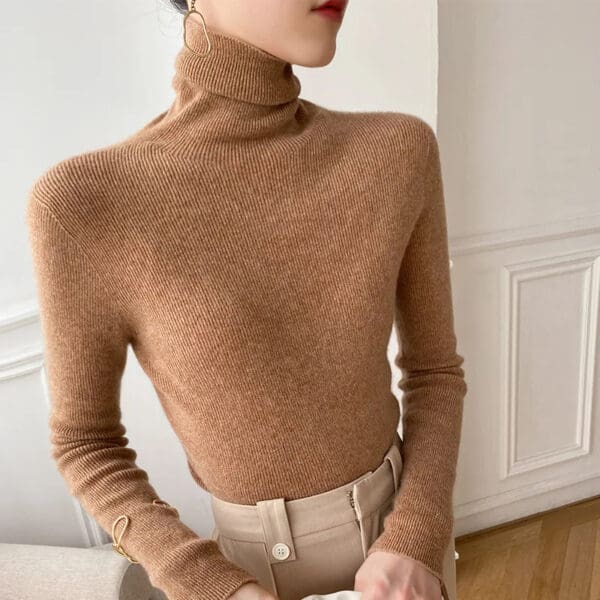 A woman in tan sweater and beige pants.