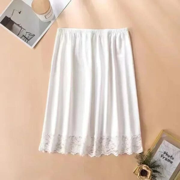 A white skirt with lace trim on the bottom.