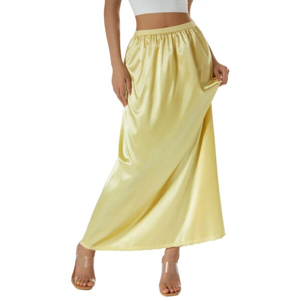 A woman wearing a yellow skirt and white top.