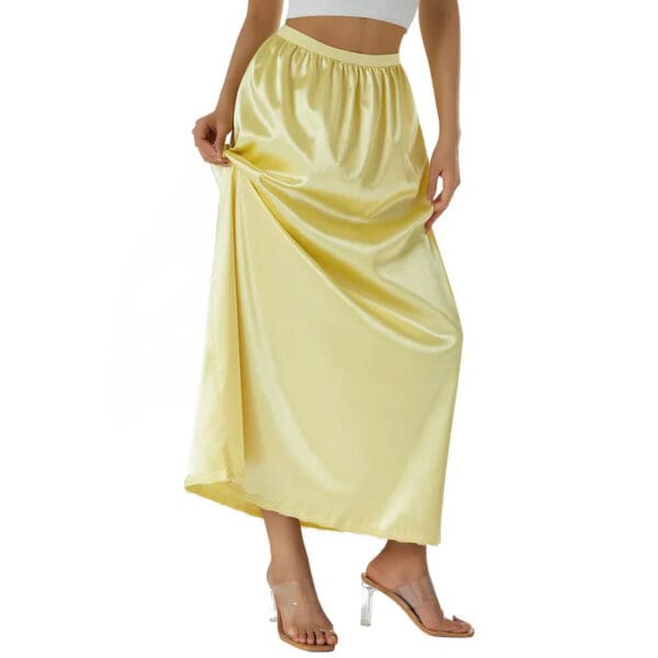 A woman wearing a yellow skirt and white top.