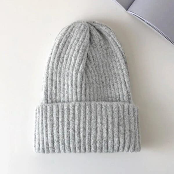 A light gray beanie is sitting on top of a table.