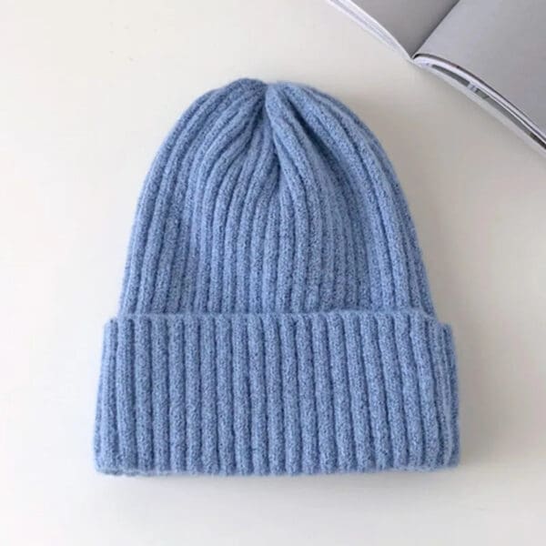 A blue beanie is sitting on top of a table.