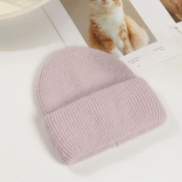 A pink beanie is sitting on top of a table.