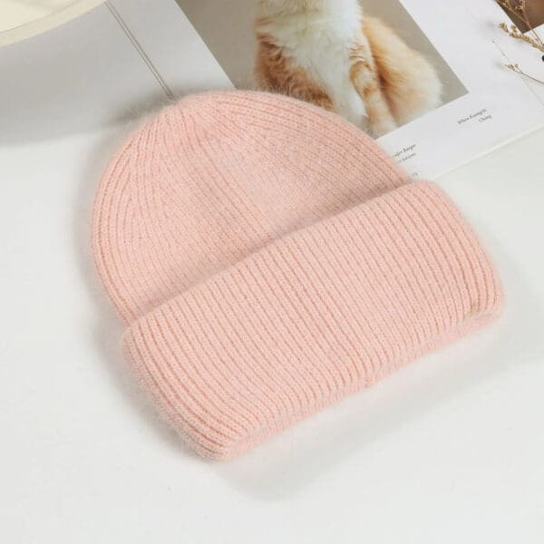 A pink beanie is sitting on the floor.