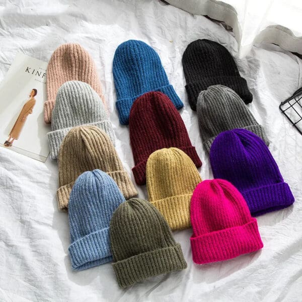 A group of hats sitting on top of a bed.