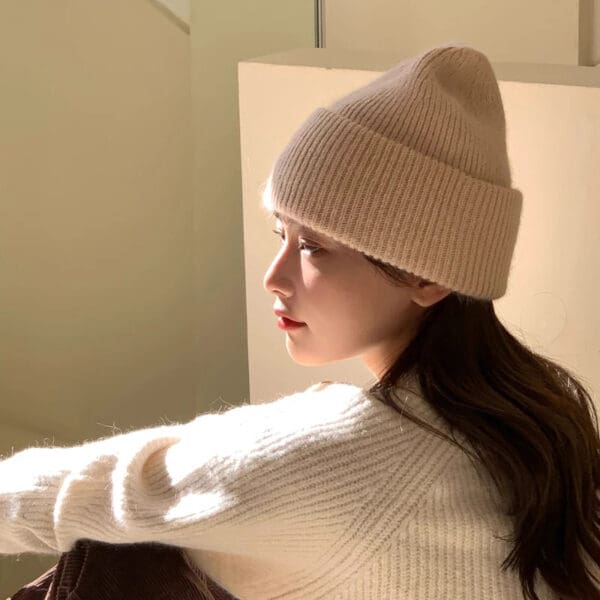 A woman wearing a white hat and sweater.