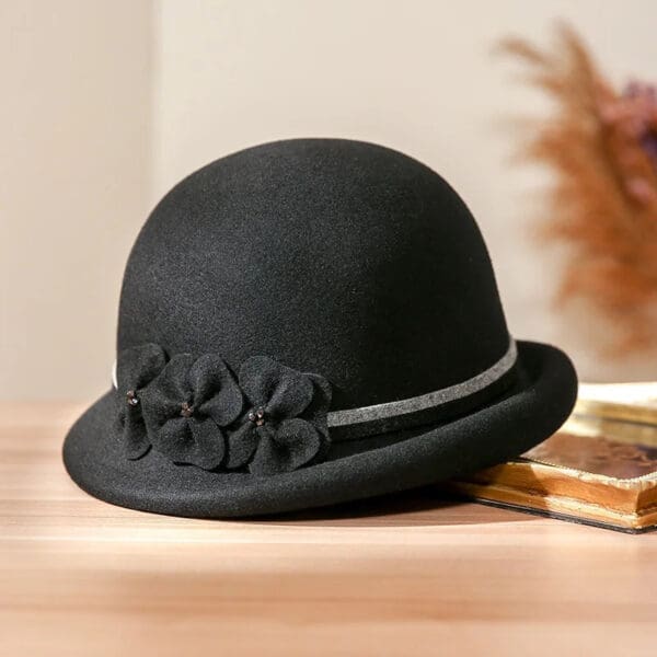 A black hat sitting on top of a wooden table.