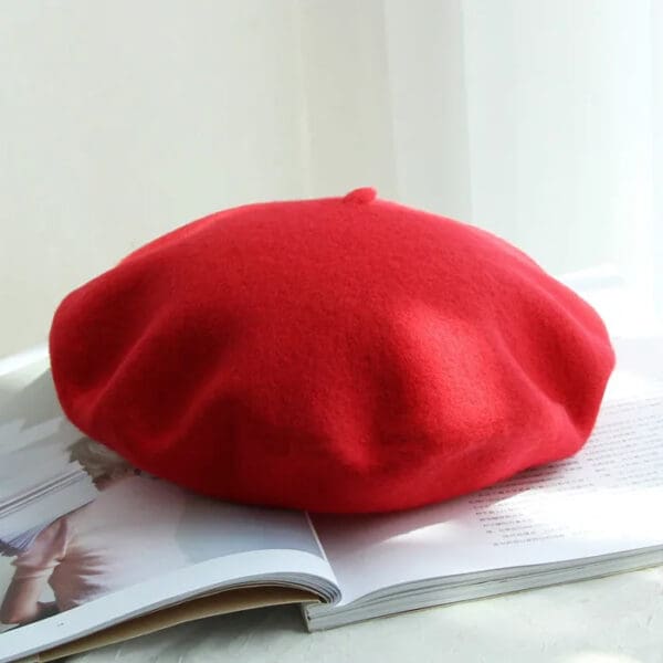 A red beret sitting on top of a book.