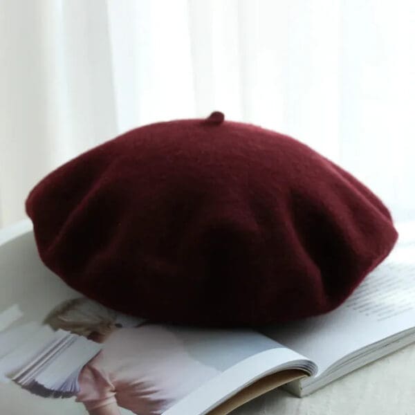 A red beret sitting on top of a magazine.