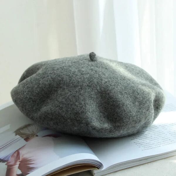 A gray hat sitting on top of a magazine.