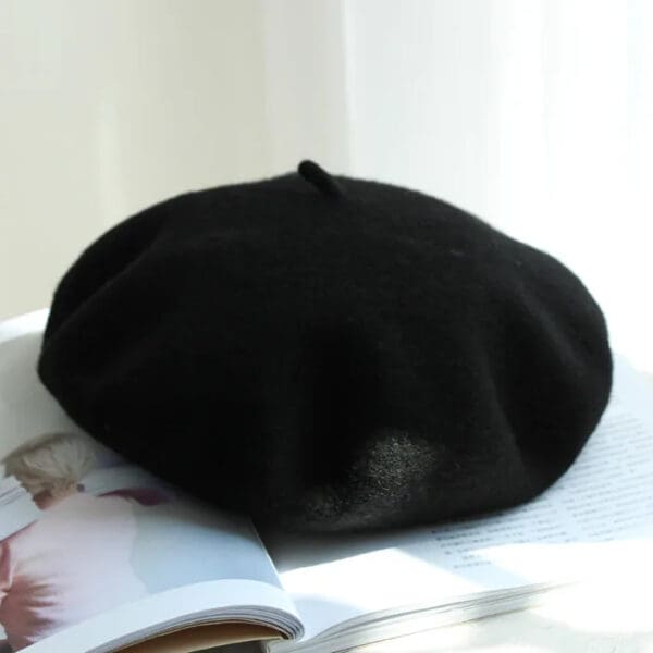 A black beret is sitting on top of a book.