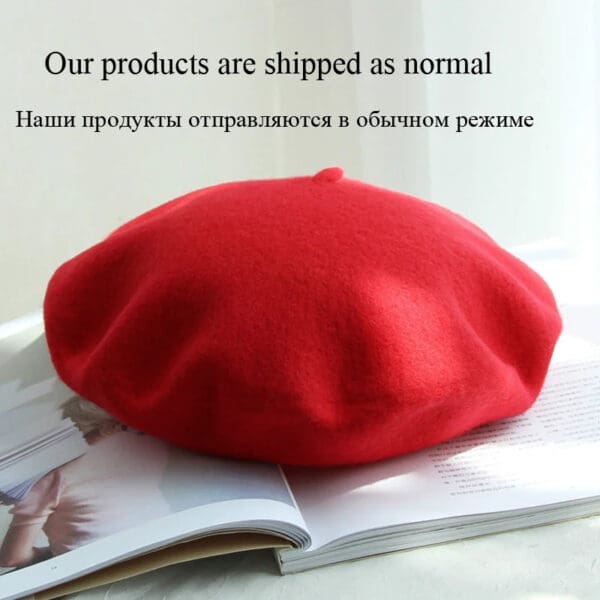 A red beret sitting on top of an open book.