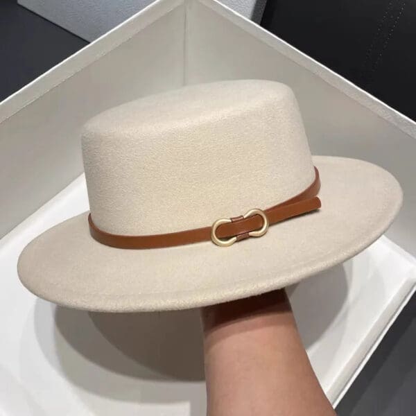 A person holding onto the hat in their hand