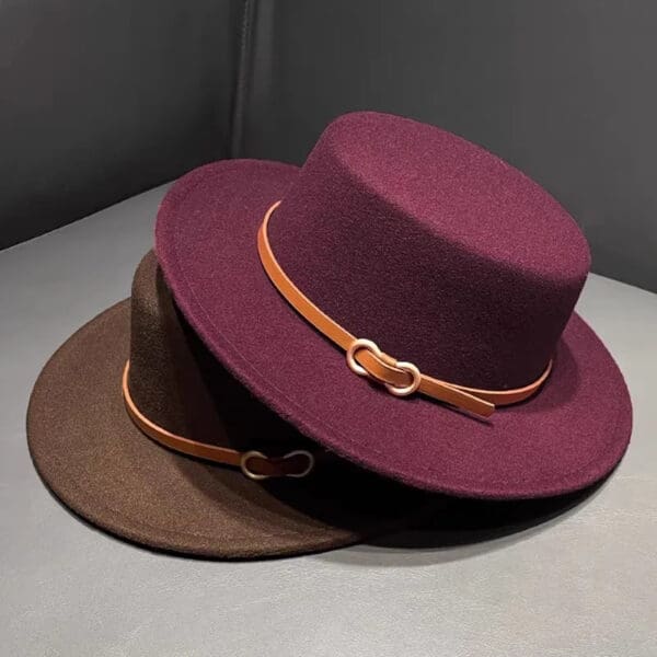 Two hats are sitting on a table.