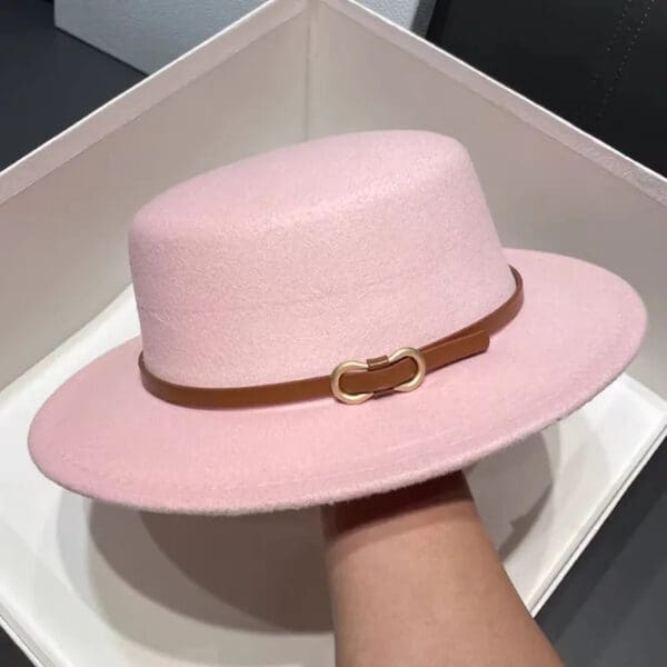 A person holding onto a hat in their hand