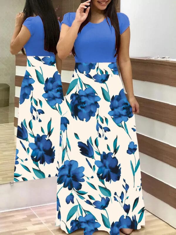 A woman standing in front of a mirror wearing a blue floral dress.