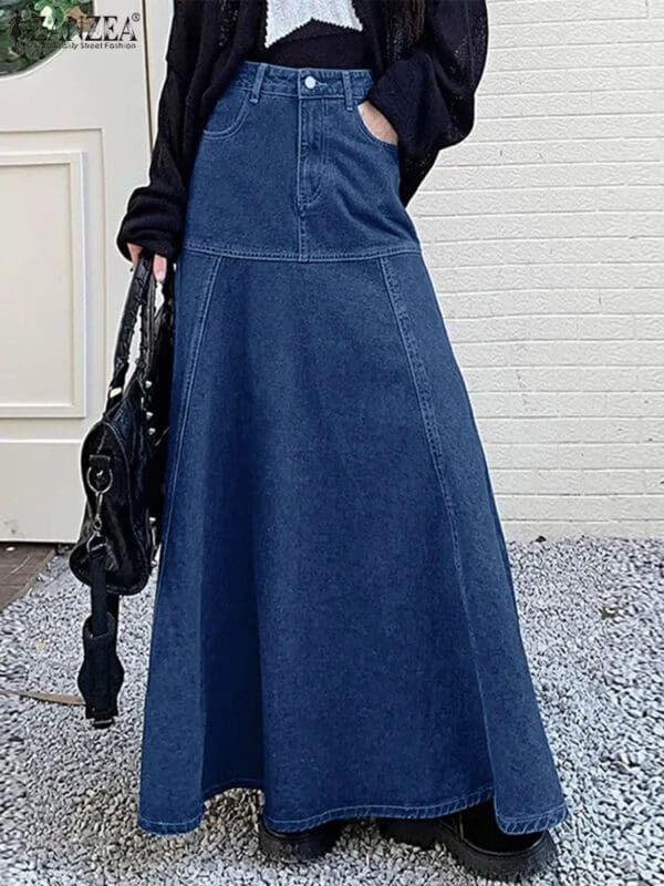 A woman in blue denim overalls holding onto a black purse.